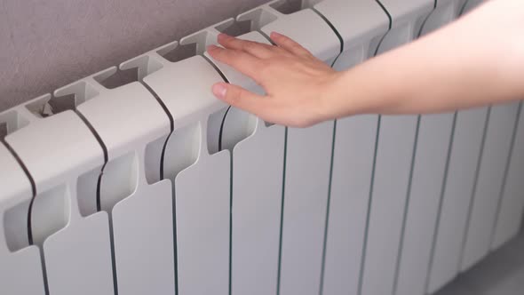 Woman's Hand Touches the Radiator