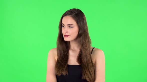 Young Woman Stands Waiting on Green Screen