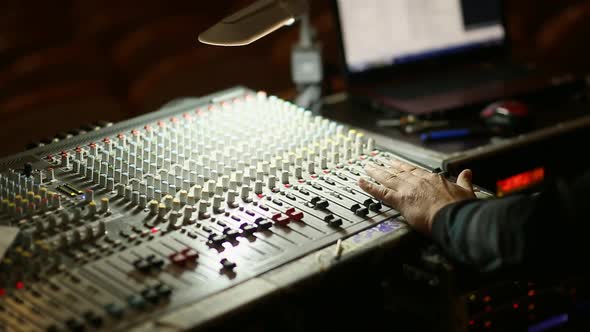 Professional's Hand Working On Audio Mixer In Studio