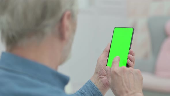 Rear View of Old Man Looking at Smartphone with Chroma Key Screen