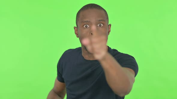 Angry Young African Man Abusing on Green Background