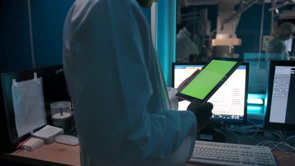 Anonymous Black Doctor Reading Data From Tablet in Lab
