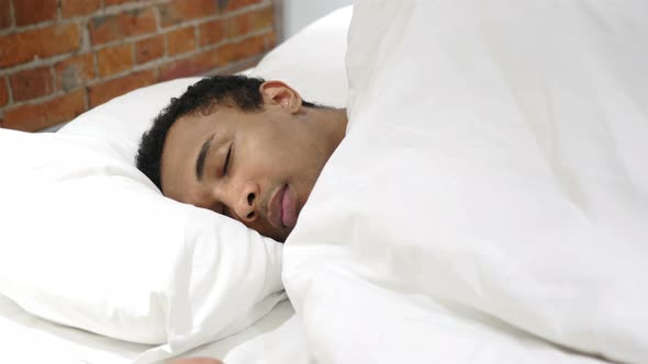 African Man Sleeping on Side in Bed at Night