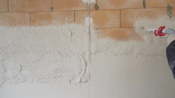 Machine Application of Plaster on a Concrete Wall