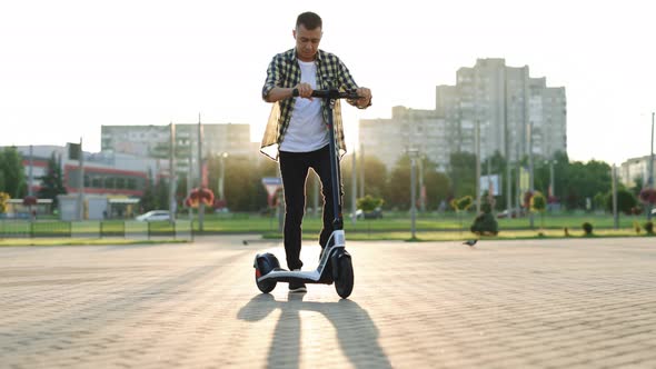 Male Staring a Ride on Electric Scooter on The Bicycle Line in the City Enviroment