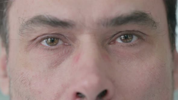 Close Up of Blinking Eyes of Middle Aged Man Looking at the Camera