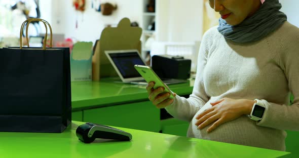 Pregnant woman paying bill at counter 4k