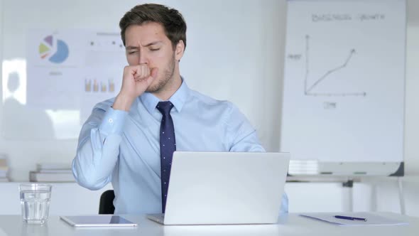 Sick Young Businessman Coughing at Work