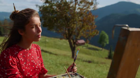 Woman Artist Mixing Paints on Color Palette Drawing Green Meadow Close Up