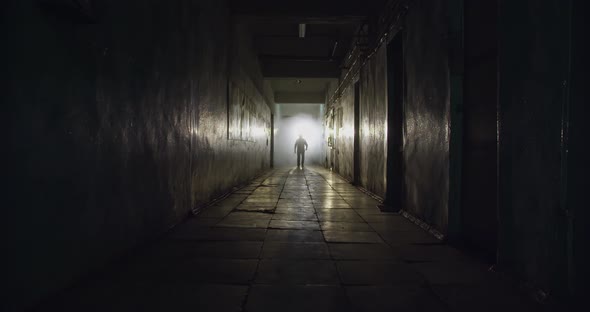 Silhouette Man Walking Down Dark Corridor Backlight