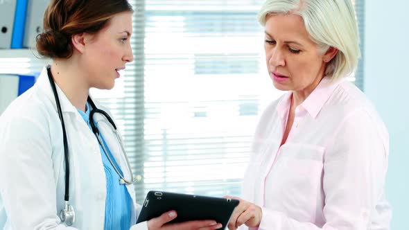 Female doctor interacting over a report on digital tablet with a patient