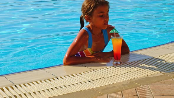 The Child is Drinking a Cocktail By the Pool