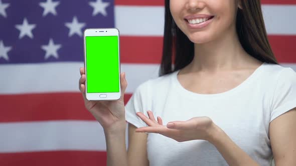 Smartphone With Green Screen in Female Hands, USA Flag Background, Application