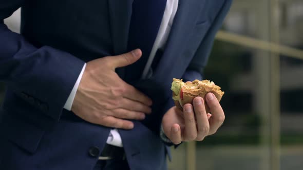 Office Worker Feeling Abdominal Discomfort While Eating Unhealthy Hamburger