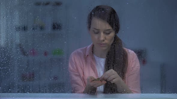 Upset Poor Lady Counting Coins Behind Rainy Window, Poor Budget, Low Incomes