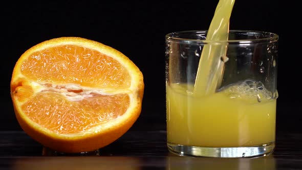 Pouring Orange Juice From Glass Jar Into Glass