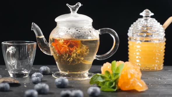 Green Chinese Flower Tea Blooming in Glass Teapot