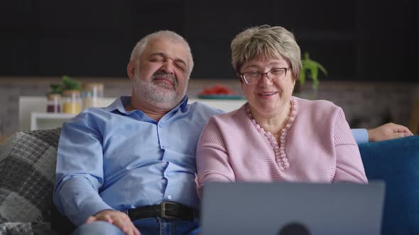 Happy Grandfather and Grandmother are Communicating By Online Video Chat with Friends or Children