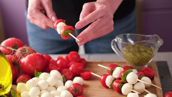 Making Caprese Canapes Sticking Cherry Tomatoes and Mozzarella Cheese Balls on a Skewer