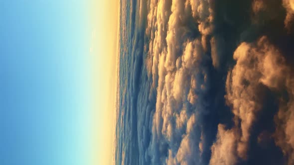 Vertical Video of Fast Fluffy Cotton Clouds at Amazing Sunset Aerial View From the Plane