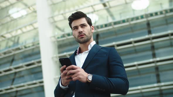 Portrait Businessman Using Phone. Man Looking Away in Stylish Suit at Street