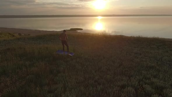 Young Sportive Man Practicing Yoga at Sunset