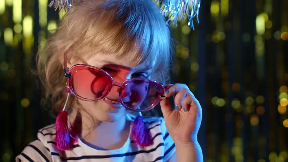 Stylish Trendy Child Kid in Sunglasses at Disco Party Cyberpunk Club Looking at Camera and Smiling