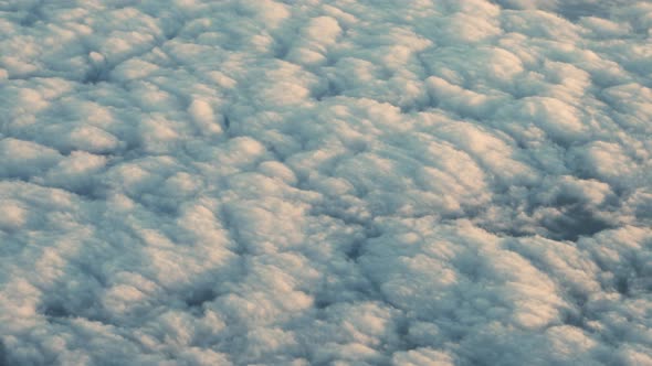 Airplane Flight Of Sunlit Clouds Covering Landscape