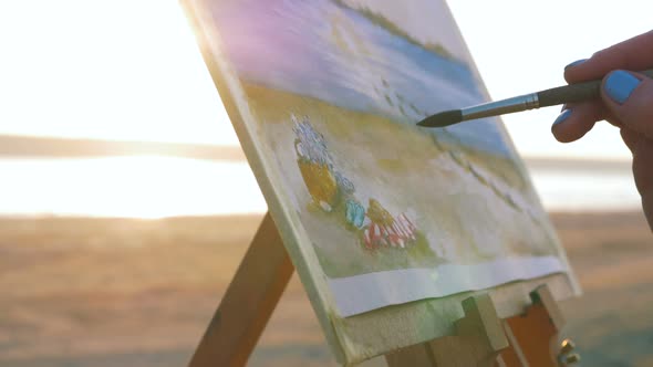 Young Woman Artist Painting Landscape in the Open Air on the Beach Close Up