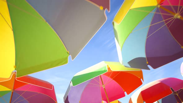 Vacations and travel concept. Colorful umbrellas or parasols against blue sky.