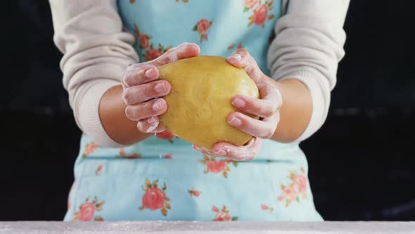 Woman molding a dough