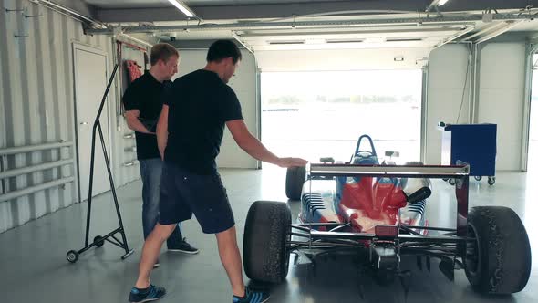 Racing Car is Getting Inspected By Two Experts