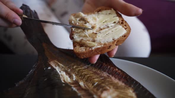 Person making delicious fresh fish sandwich with kitchen knife, close up