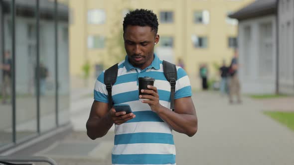 African American Man Having a Walk in the Town Enjoying His Tasty Coffee