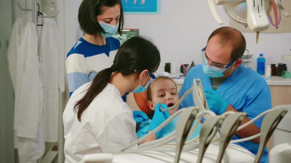 Child Sitting in Stomatological Chair Opening Mouth