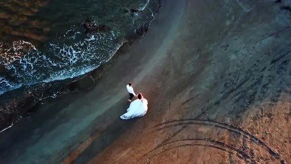 Loving Couple Walking on Beach  At Sunset