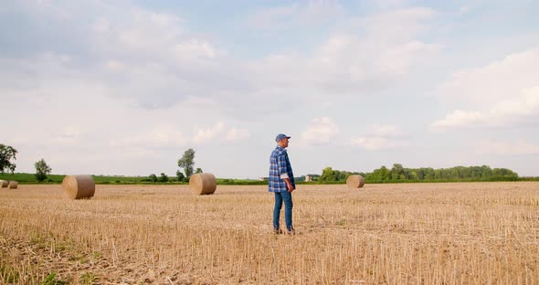 Farmer Using Digital Tablet While Examining Field