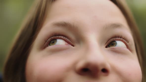 Happy Young Caucasian Girl, Natural Beauty, Smiling in the Nature. Extreme Close Up on Her Green