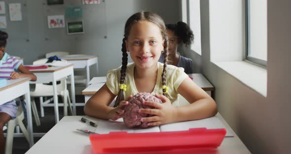 Video oh happy caucasian girl holding brain model during biology lesson