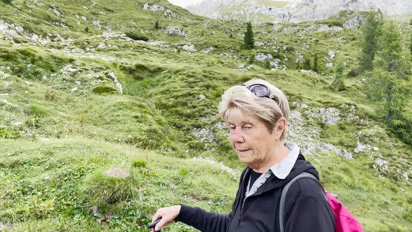 Elderly Woman Along a Mountain Trail in Summer Season