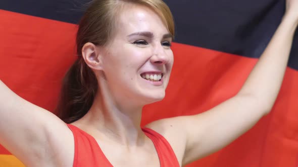 German Young Woman Celebrates Holding the Flag of Germany