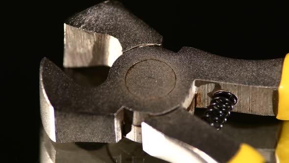 Part of Wire Cutters with Yellow, Gray Handle on Black, Reflection, Close Up, Rotation