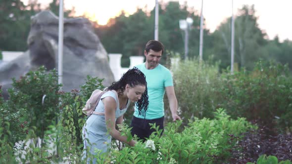 Adult Man and Woman Walk at the Garden and Talk