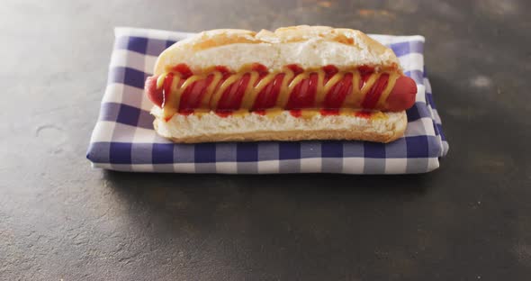 Video of hot dog with mustard and ketchup on a black surface