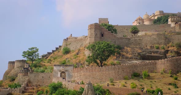 Tourists Visit Historic Indian Kumbhalgarh Fort. Old Fortress Ancient Walls on Green Aravalli Hills