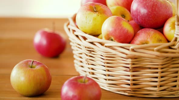 Ripe Apples in Wicker Basket on Wooden Table