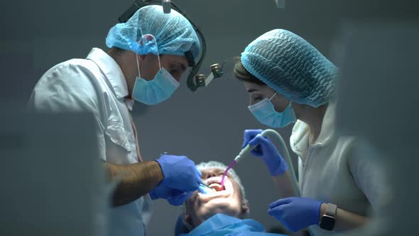 Side View Dental Assistant Removing Saliva with Sucking Tube As Doctor Injecting Anesthesia in Mouth