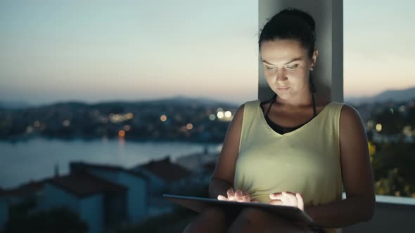 Girl Working at Home on the Porch Online at Sunset