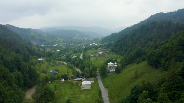 Aerial View of a Road in the Middle of the Green Forest