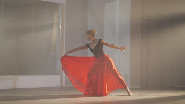 Slim Woman in Long Scarlet Red Skirt and Pointes Jumping and Bending in Slow Motion in Backlit Fog
